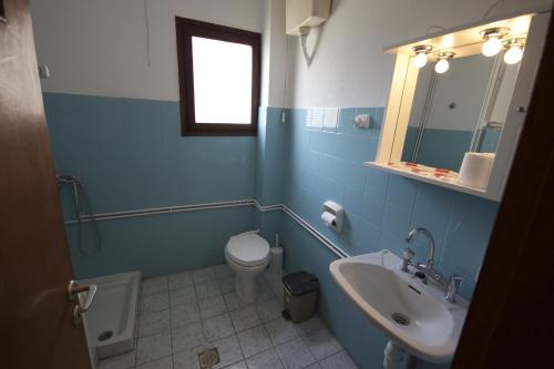 ein blaues Badezimmer mit WC und Waschbecken in der Unterkunft Hotel Sevilli in Agios Ioannis