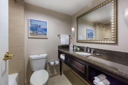 a bathroom with a toilet and a sink and a mirror at Hilton Irvine/Orange County Airport in Irvine
