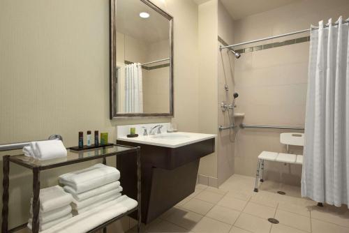 a bathroom with a sink and a shower at Embassy Suites Saint Louis - Downtown in Saint Louis