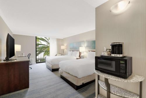 a hotel room with two beds and a television at Hilton Irvine/Orange County Airport in Irvine