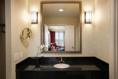 a bathroom with a sink and a mirror at President Abraham Lincoln - A Doubletree by Hilton Hotel in Springfield