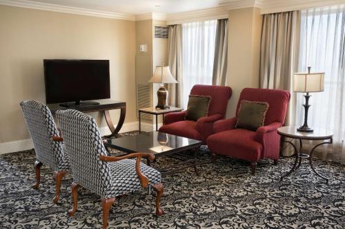 a living room with two chairs and a television at President Abraham Lincoln - A Doubletree by Hilton Hotel in Springfield