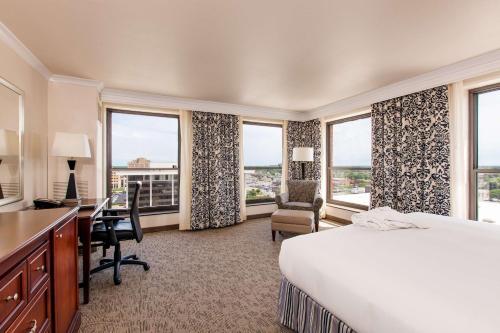 a hotel room with a bed and desk and windows at President Abraham Lincoln - A Doubletree by Hilton Hotel in Springfield