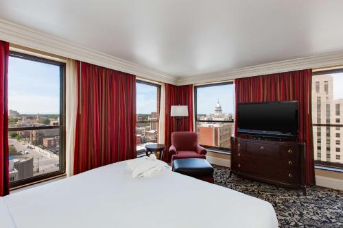 a hotel room with a bed and a flat screen tv at President Abraham Lincoln - A Doubletree by Hilton Hotel in Springfield