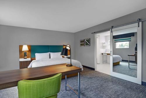a hotel room with a bed and a desk and a bedroom at Hampton Inn & Suites Belleville in Belleville