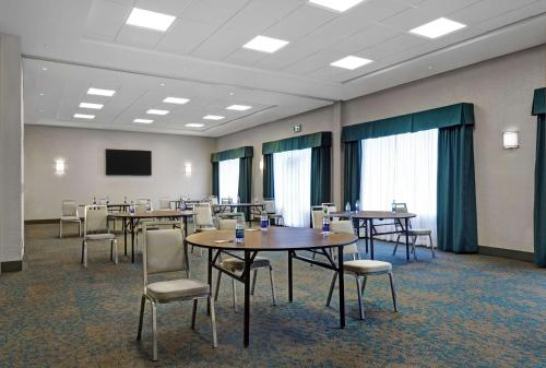 a conference room with tables and chairs and a screen at Hampton Inn & Suites Belleville in Belleville
