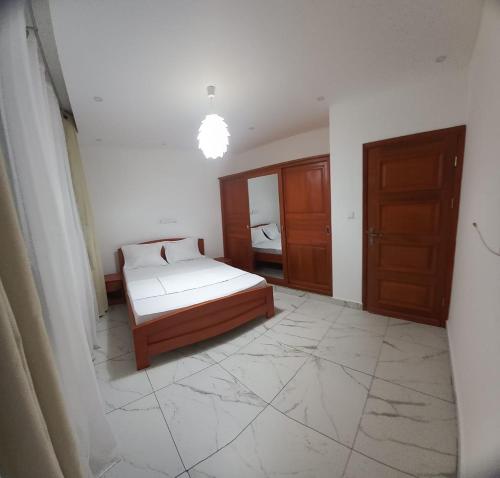 a bedroom with a bed and a room with a window at Beau T2 Nouvelle Route bastos Yaoundé in Yaoundé