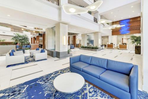 a lobby with a blue couch and white chairs at Embassy Suites by Hilton Anaheim-Orange in Anaheim