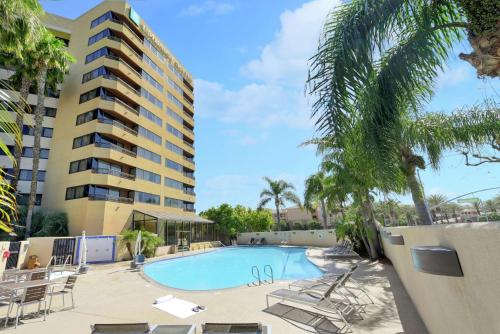 a swimming pool with chairs and a building at Embassy Suites by Hilton Anaheim-Orange in Anaheim