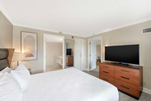 a bedroom with a bed and a flat screen tv at Embassy Suites by Hilton Anaheim-Orange in Anaheim
