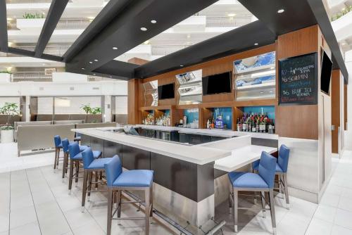 a restaurant with a bar with blue chairs at Embassy Suites by Hilton Anaheim-Orange in Anaheim