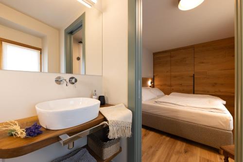 a bathroom with a sink and a bed at Maison Luboz - Courmayeur in Courmayeur