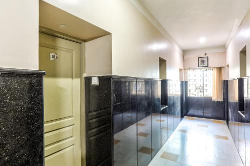 a bathroom with black and white walls and a door at flagship heavens inn in Chennai