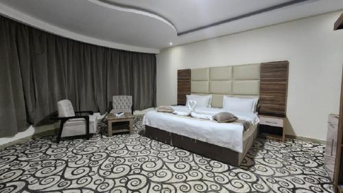 ein Hotelzimmer mit einem Bett, einem Schreibtisch und einem Stuhl in der Unterkunft منازل الماسة للشقق المخدومـة in Ha'il