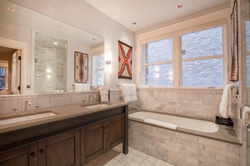 uma casa de banho com uma banheira e um lavatório e uma banheira em The Auberge Residences at Element 52 em Telluride
