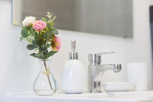 un vase rempli de fleurs assis sur un évier dans l'établissement L’azur - 3 personnes - Bureau & wifi, à Perpignan