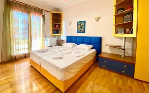 a bedroom with a large bed with a blue headboard at “Stadium” Apartment in Tirana