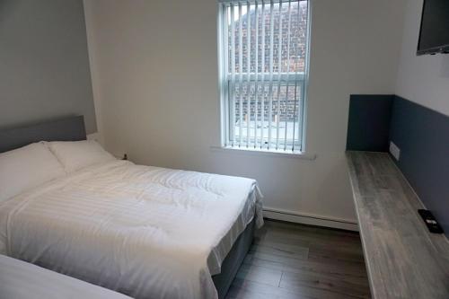 a bedroom with two beds and a window at Townsend lane accommodation in Liverpool