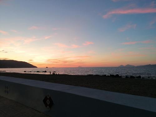una puesta de sol en una playa con gente en la playa en Casa vacanze Sabbie di Giove, en Patti