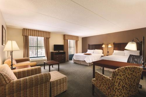 a hotel room with two beds and a couch at Hampton Inn & Suites Lake George in Lake George