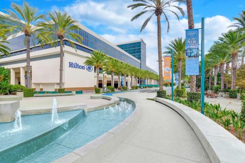 a shopping mall with palm trees and a fountain at Hilton Anaheim in Anaheim