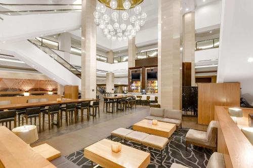 un restaurante con mesas y sillas y una lámpara de araña en Hilton Anaheim, en Anaheim