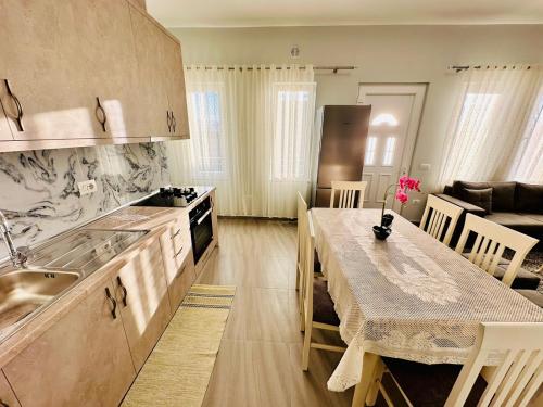 a kitchen and dining room with a table and a kitchen and a dining room at Rrjolli View Beach in Velipojë