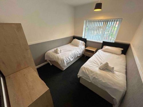 a bedroom with two beds and a window at Lovely house & driveway parking in Kidsgrove