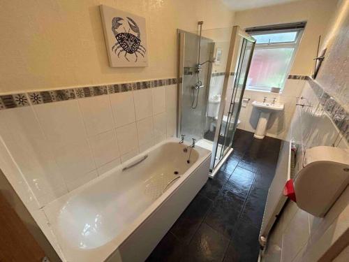 ein Bad mit einer Badewanne, einer Dusche und einem WC in der Unterkunft Lovely house & driveway parking in Kidsgrove