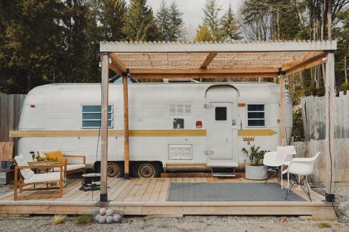 a white trailer with a gazebo on a deck at Dreamy Airstream Hideaway with Hot Tub in Gibsons