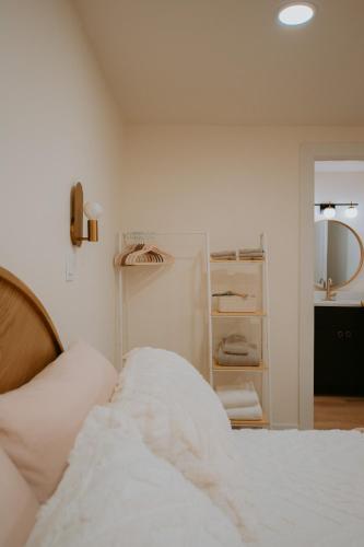 a white bedroom with a bed and a closet at East Downtown Desert Chic Casita-Hot Tub-Pet Friendly-No Pet Fees! in Albuquerque