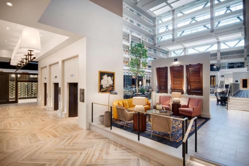 a lobby with couches and chairs in a building at Embassy Suites by Hilton Atlanta Buckhead in Atlanta