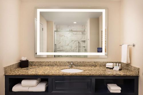 baño con lavabo y espejo grande en Embassy Suites by Hilton Atlanta Buckhead en Atlanta