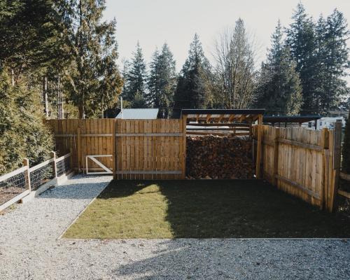 a wooden fence with a gate in a yard at Dreamy Airstream Hideaway with Hot Tub in Gibsons