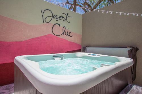 a bath tub in a room with a sign that reads desert club at East Downtown Desert Chic Casita-Hot Tub-Pet Friendly-No Pet Fees! in Albuquerque