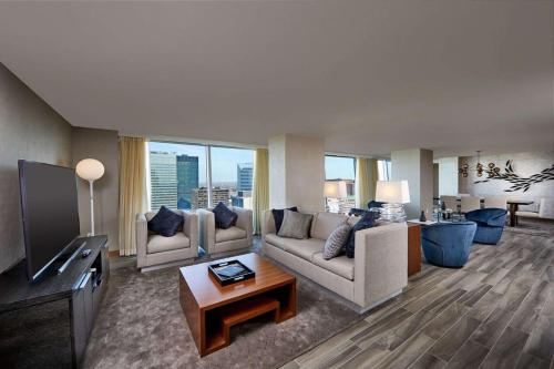 a living room with couches and a flat screen tv at Hilton Cleveland Downtown in Cleveland