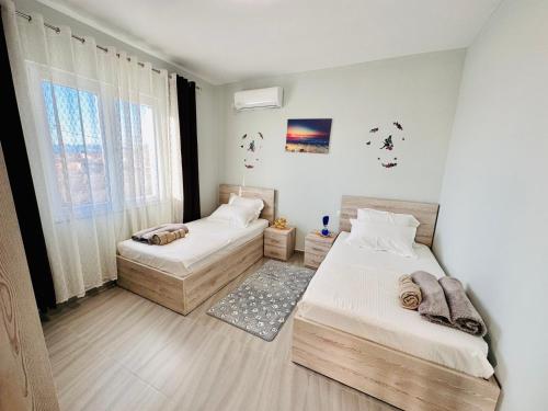 a bedroom with two beds and a window at Rrjolli View Beach in Velipojë
