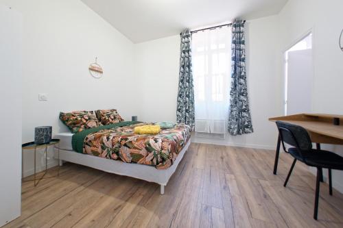 une chambre avec un lit, une table et un bureau dans l'établissement L’azur - 3 personnes - Bureau & wifi, à Perpignan