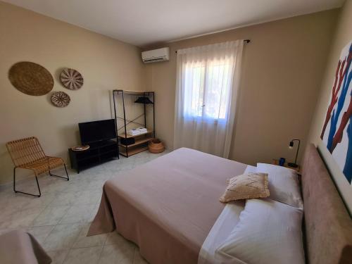 a bedroom with a large bed and a television at Casa Calilla - 30m dal mare in Lampedusa
