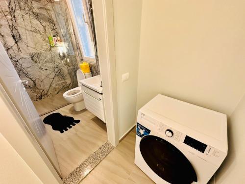 a washing machine in a bathroom with a toilet at Rrjolli View Beach in Velipojë
