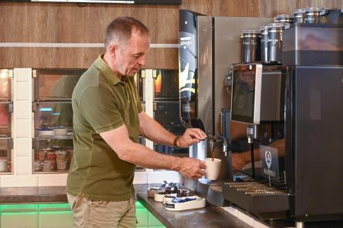 een man die in een keuken staat en een drankje maakt bij Augustus Hotel Bernkastel - Comfortable Budget Hotel in Bernkastel-Kues