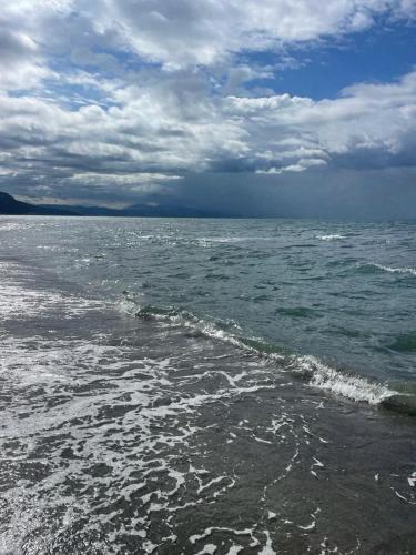 a body of water with a cloudy sky and waves at Rrjolli View Beach in Velipojë