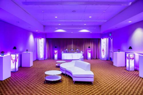 a purple room with a white couch and tables and chairs at Hilton Vancouver Washington in Vancouver