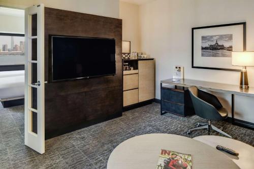 a hotel room with a flat screen tv and a desk at DoubleTree by Hilton Hotel & Suites Jersey City in Jersey City