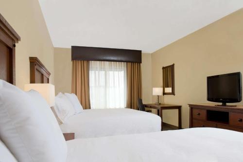 a hotel room with two beds and a television at Homewood Suites by Hilton Bozeman in Bozeman