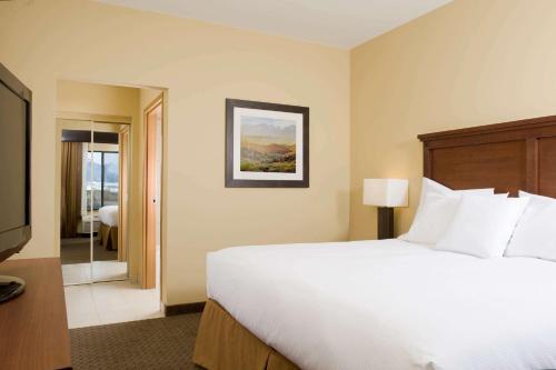 a hotel room with a bed and a television at Homewood Suites by Hilton Bozeman in Bozeman