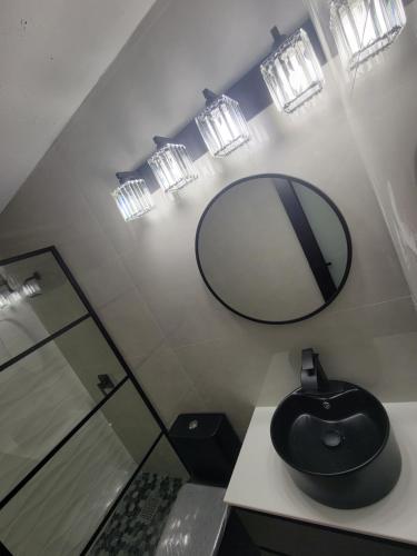 a bathroom with a mirror and a black mouse on a counter at Casa Elegante cerca aeropuerto y zona turistica in Canovanas