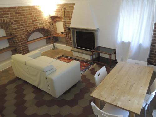 a living room with a couch and a table and a fireplace at La Casa Di Cocca in Alba