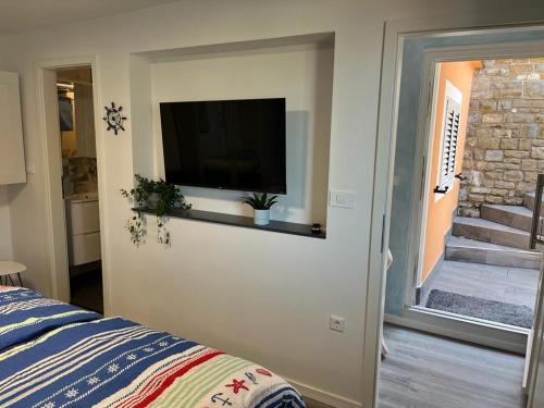 a bedroom with a flat screen tv on the wall at Apartment Emma in Piran