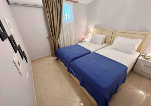 una camera d'albergo con due letti con lenzuola blu di Paschali apartment with 2 bedrooms in Ammoudia a Párga